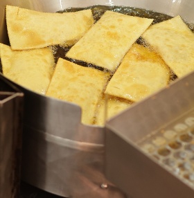 Pastéis fritando no tacho de óleo